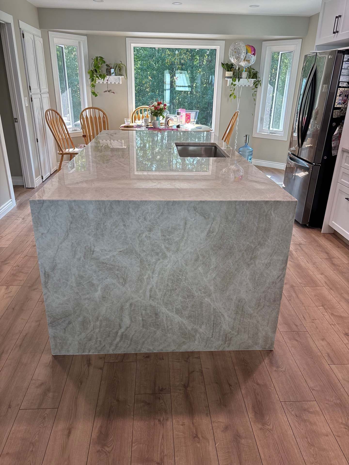Dramatic veined stone island in a bright kitchen