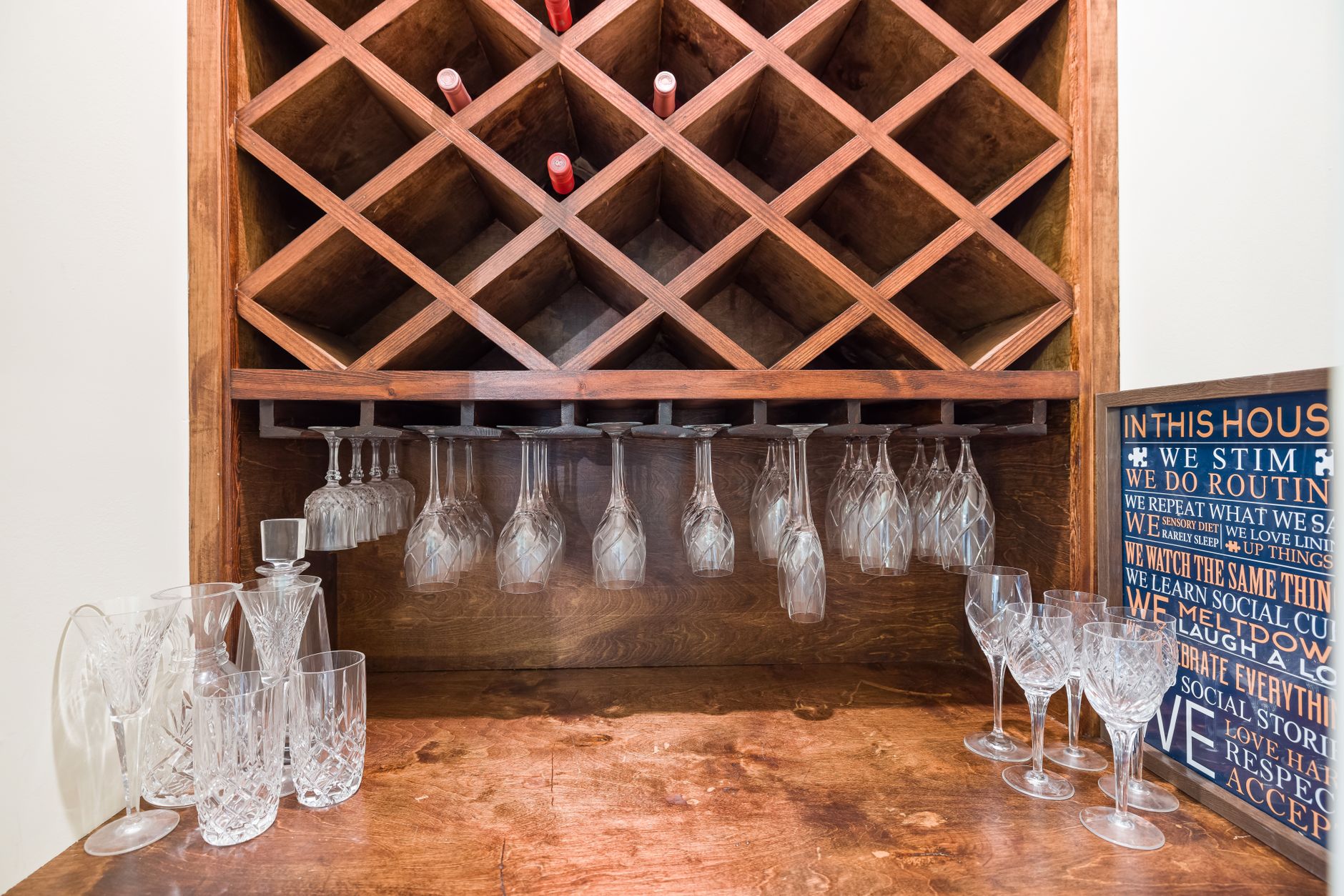 Custom wine storage cabinetry with wooden racks and glassware display